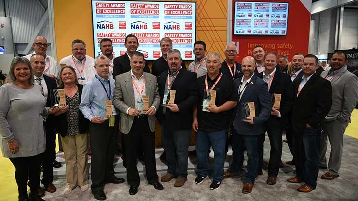 Group of men and women smiling, holding awards